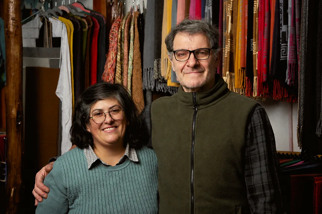 Paula García y René Daccarett en la tienda de Papiteje, entre piezas tejidas colgadas